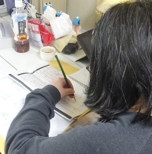 利き手でない左手でメモ用紙に書き写す