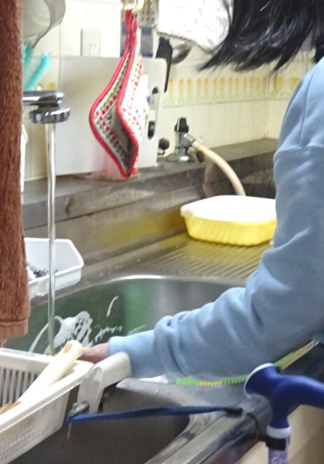 スポンジたわしでシンクを洗う